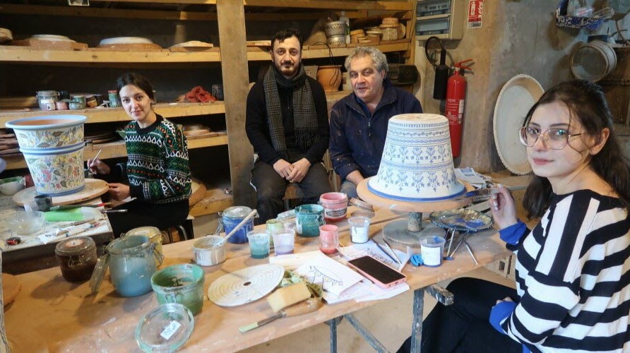 les trois céramistes posant devant leur poste de travail dans l'atelier de François Fresnais